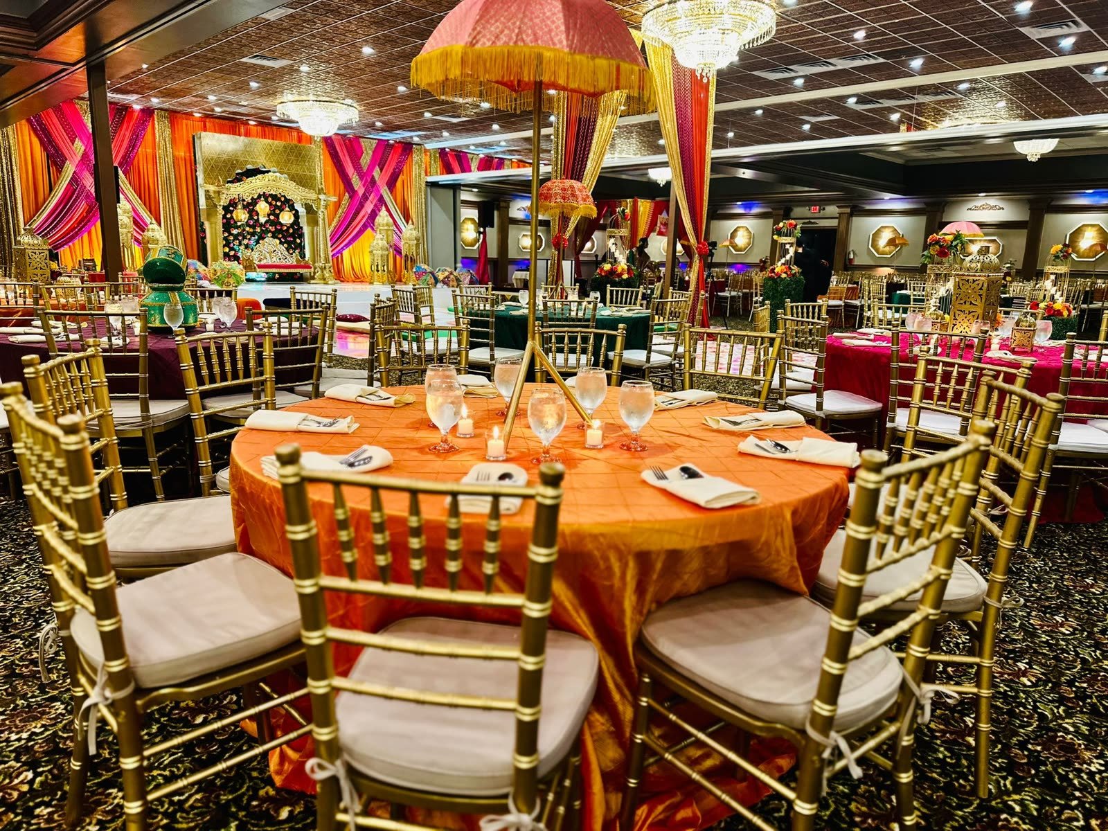 A table laid in orange and gold, place settings out