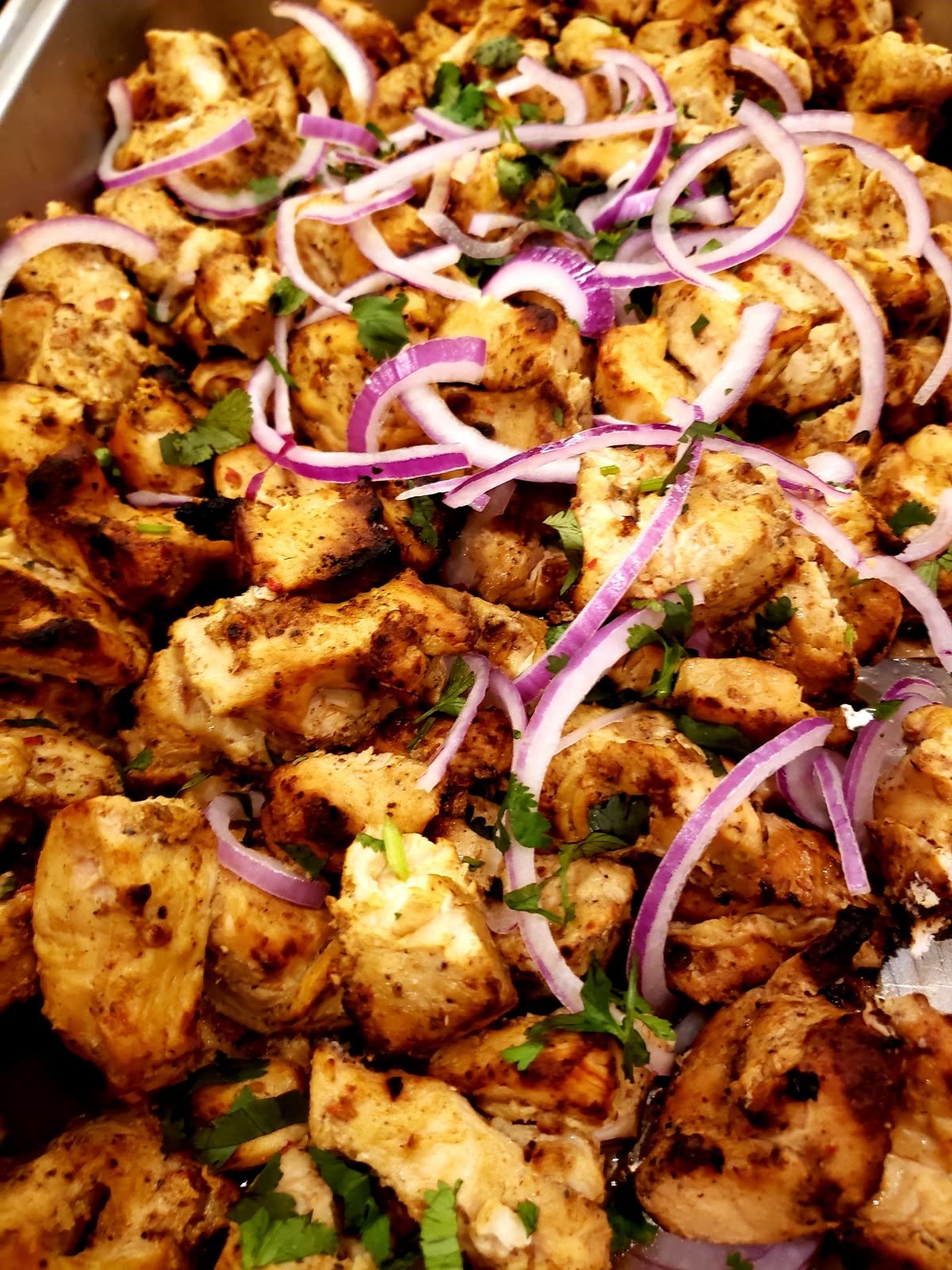 Charcoal-grilled chicken tikka with sliced onion