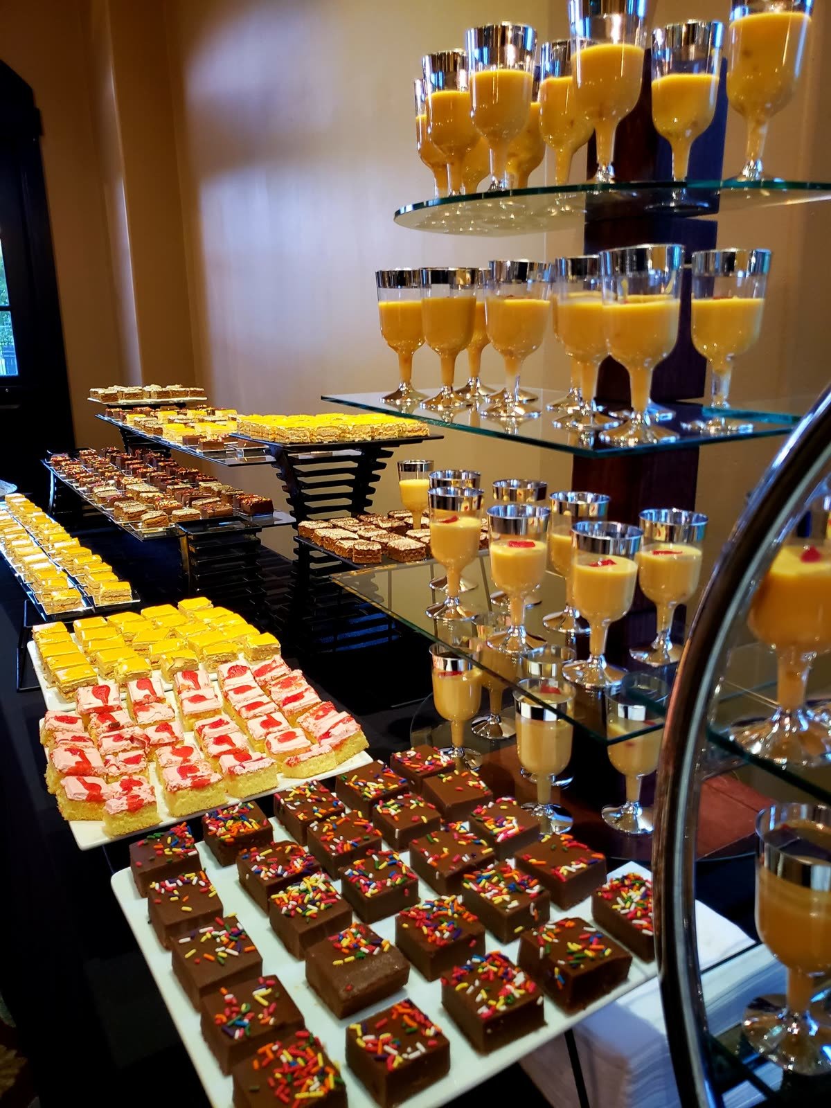 A dessert display of mousse glasses and pastries