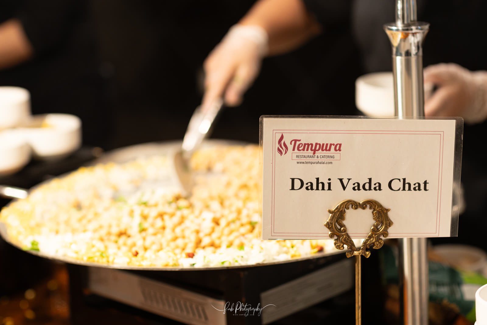A live chaat station at a Marquee event, under a Tempura menu card