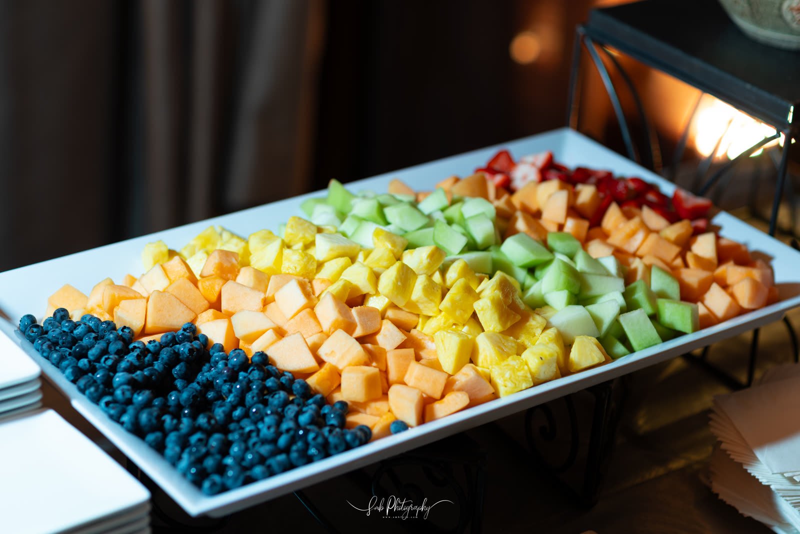 Sliced fruit and berries along the counter